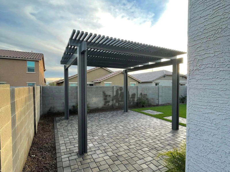 Dark gray freestanding lattice pergola on pavers