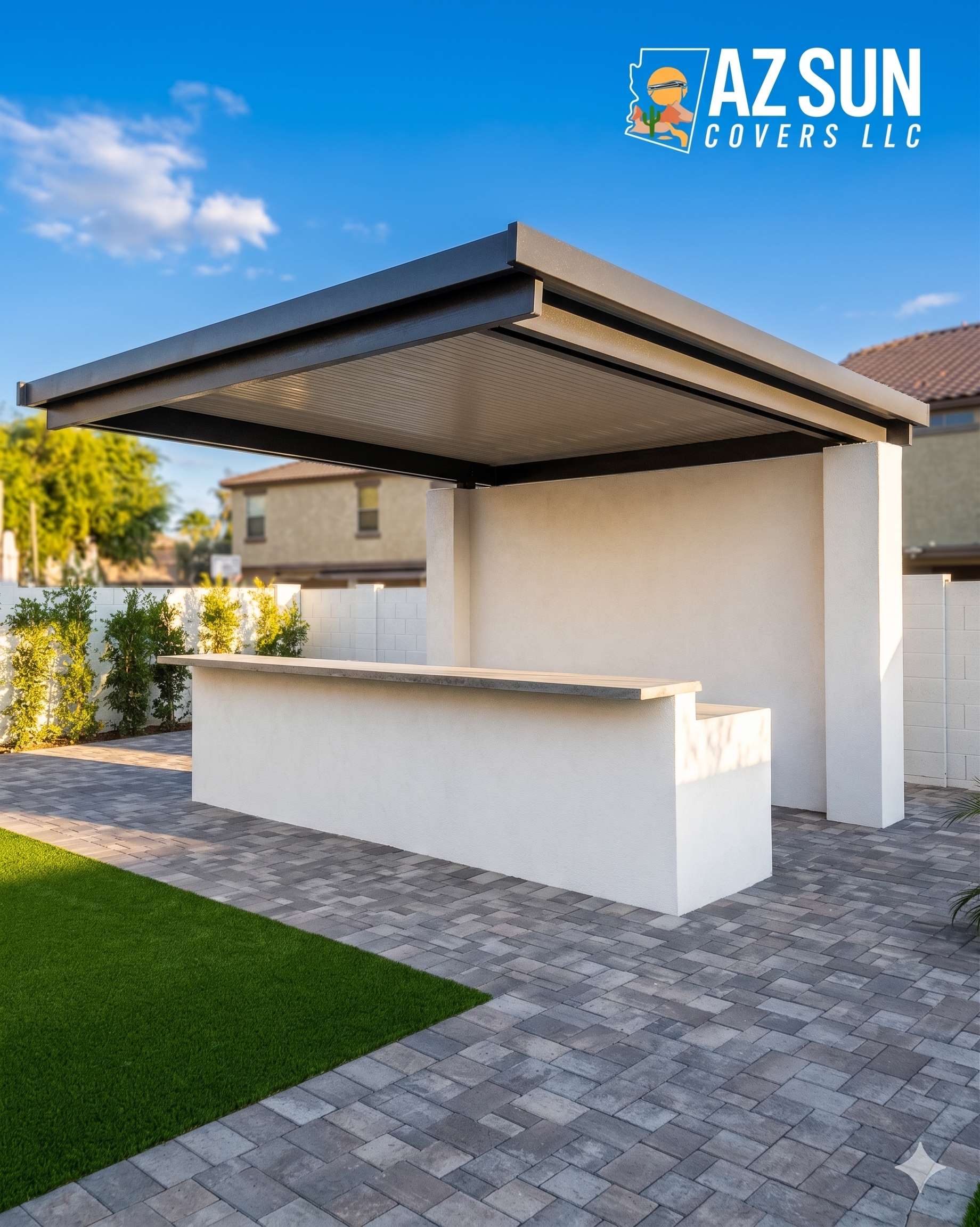 White stucco outdoor kitchen with solid roof on gray pavers