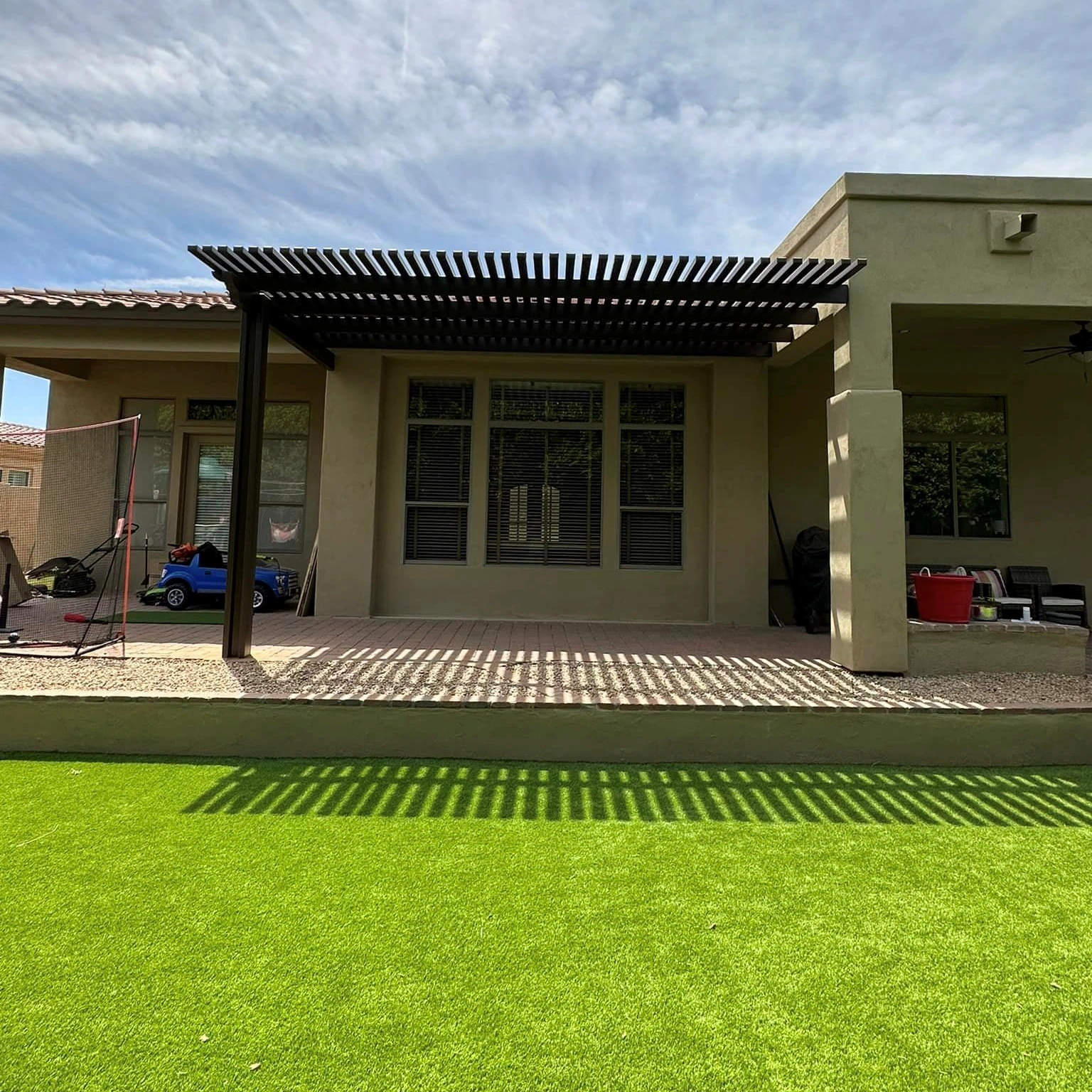 Dark lattice sun cover with shadow patterns on turf